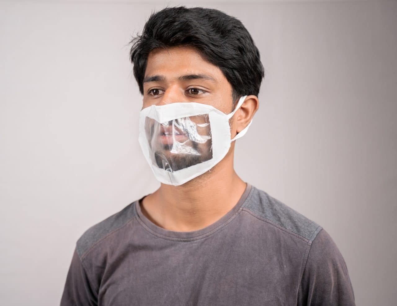 young man with transparent Medical face mask, to help hearing impermeant or deaf people to understand lipreading during coronavirus or covid-19 outbreak