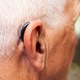 Senior man wearing discrete, modern hearing aid.