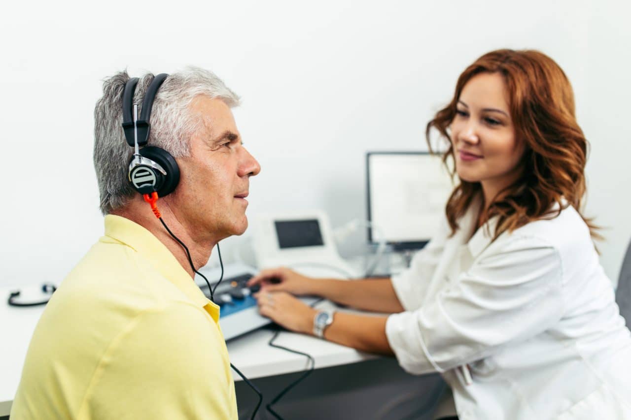 An older man receives a hearing test.
