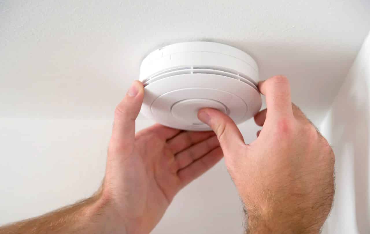 A smoke detector being set up in a home.