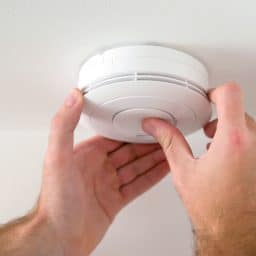 A smoke detector being set up in a home.