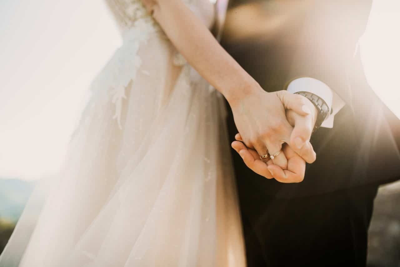 bride and groom hold hands