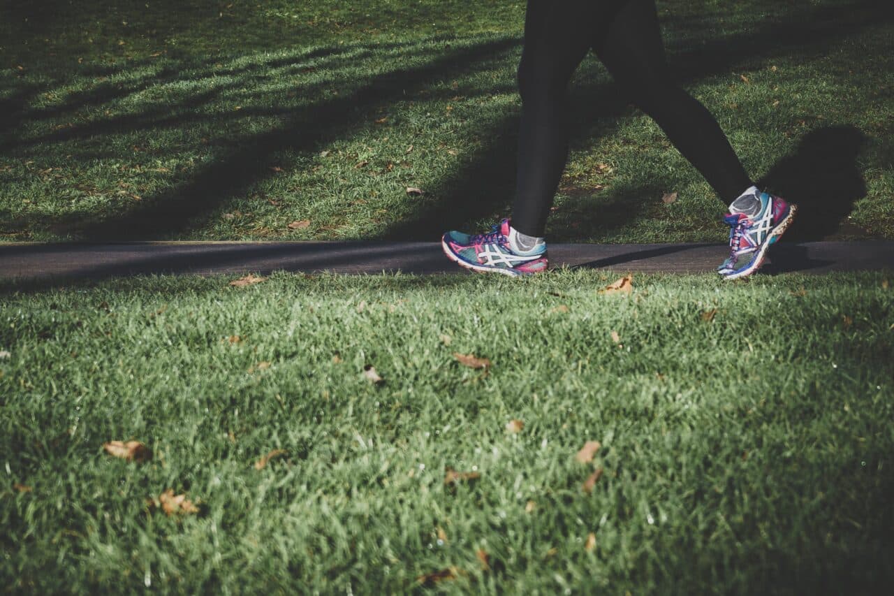 Close-up of a woman jogging in a park.