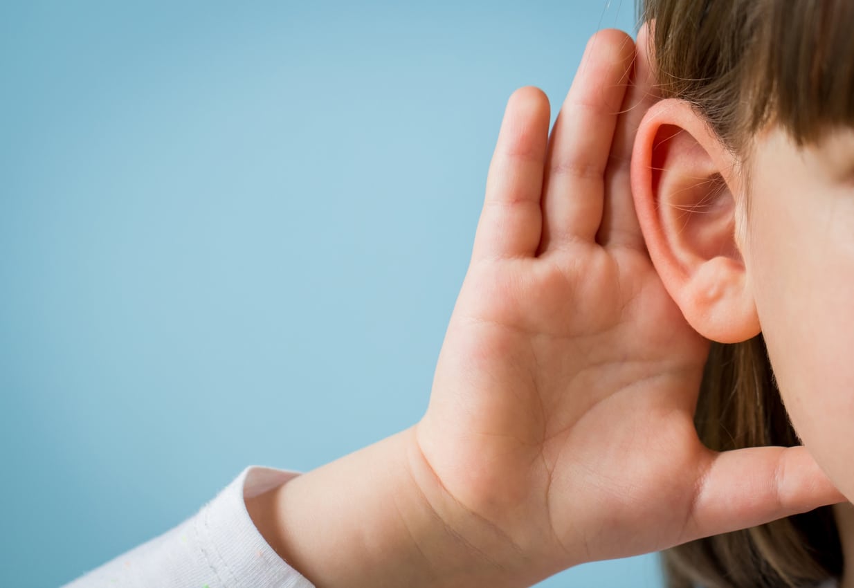 Child cups ear in attempt to hear 