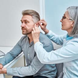 Hearing specialist fits man for hearing aid