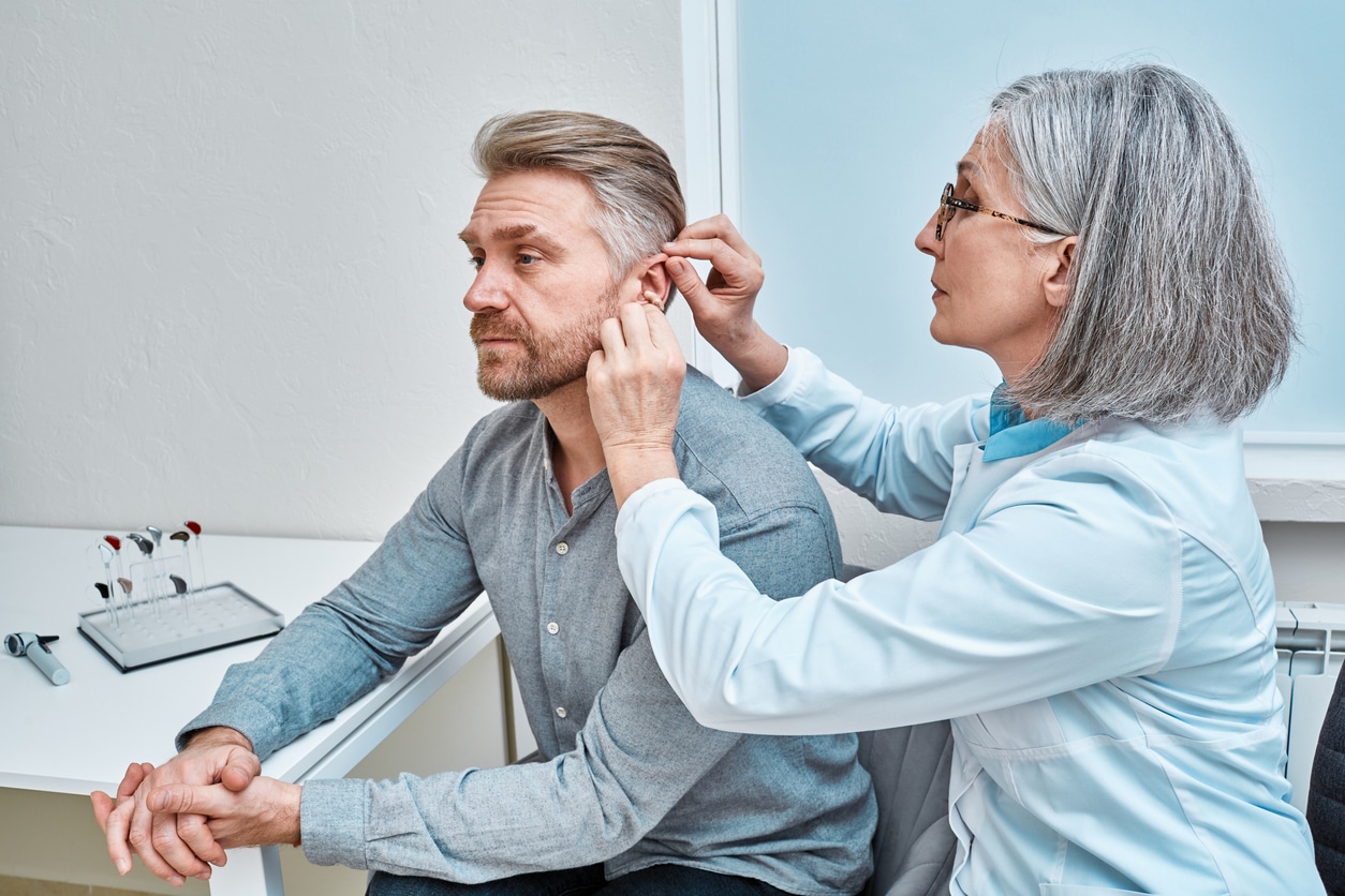 Hearing specialist fits man for hearing aid